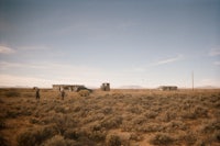 two small buildings in the middle of a desert